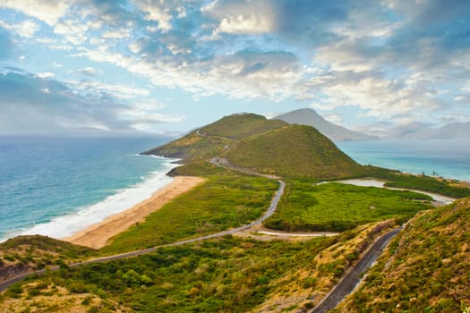 A green hilly peninsula under cloudy skies