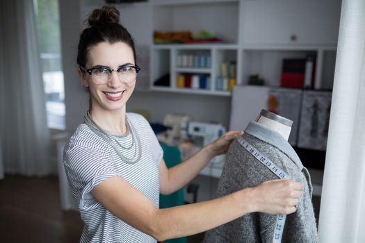 Fashion designer taking measure of fabric at home