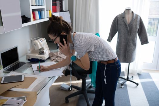 Fashion designer talking on mobile phone at home