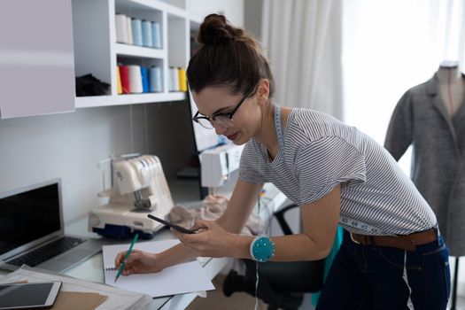 Fashion designer using mobile phone at home