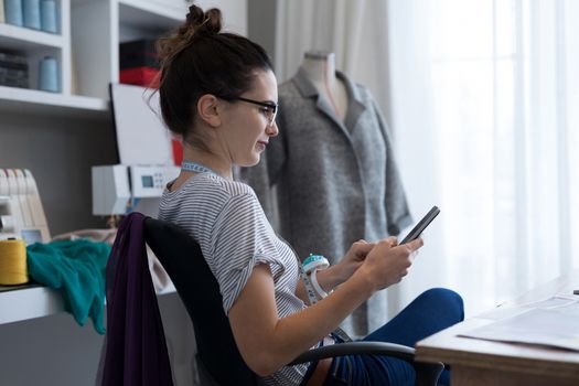 Fashion designer using mobile phone at home