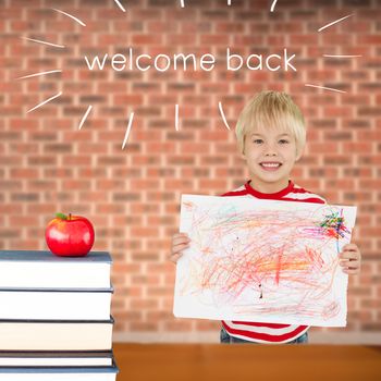 The word welcome back and cute boy showing his art against red apple on pile of books