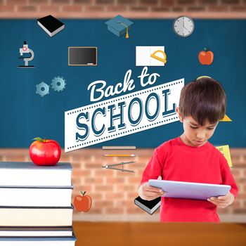 Cute boy using tablet against red apple on pile of books in classroom