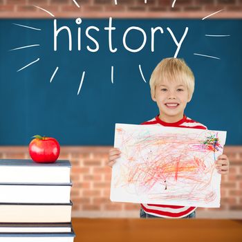 The word history and cute boy showing his art against red apple on pile of books in classroom