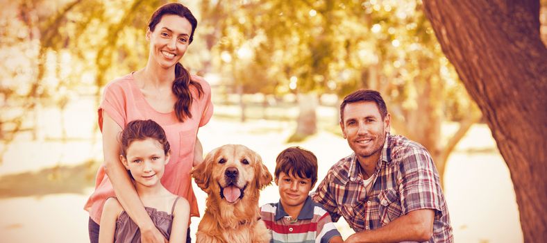 Portrait of happy family with dog in park on sunny day