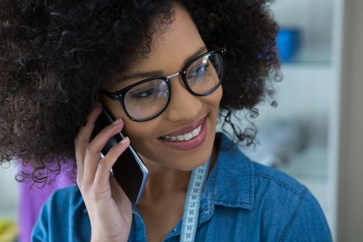 Close-up of female fashion designer talking on mobile phone