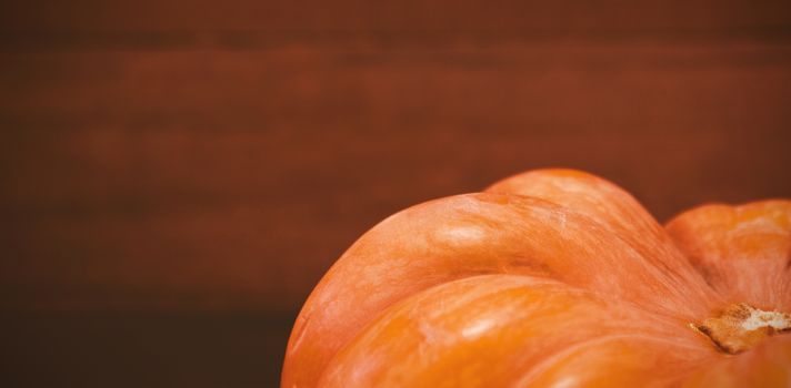 Cropped image of pumpkin against wooden plank during Halloween