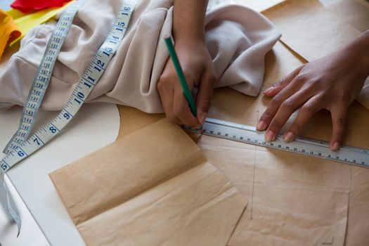 fashion designer marking on brown paper at desk