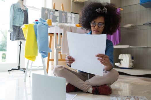 Female fashion designer looking at sketch at home