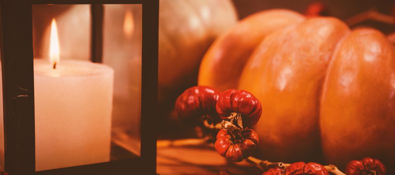 Close up of pumpkins by candle on table during Halloween