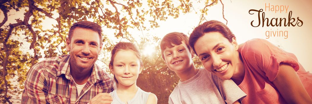 Thanksgiving greeting text against happy family smiling at park