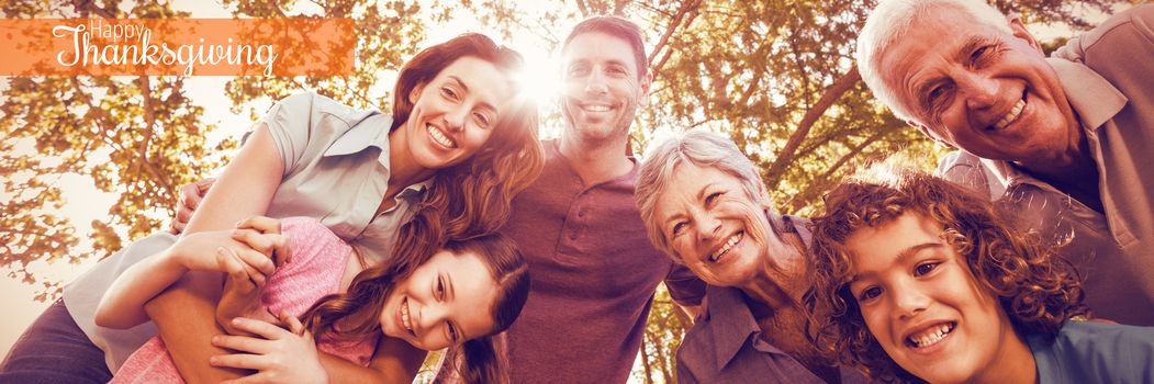 Thanksgiving greeting text against happy family smiling in park