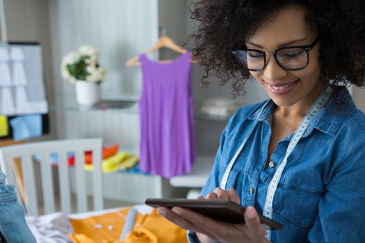 Female fashion designer using digital tablet at home