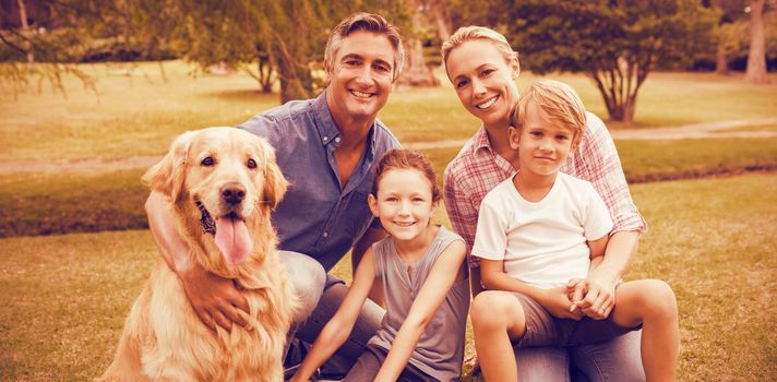 Portrait of family enjoying with dog at park on sunny day