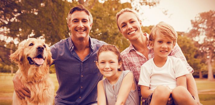 Family enjoying with dog at park on sunny day