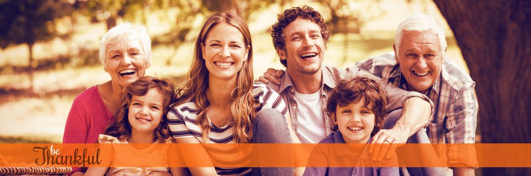 Thanksgiving greeting text against portrait of smiling family having picnic