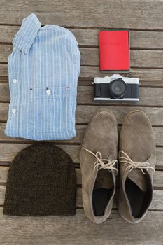 Overhead of travel accessories on wooden plank