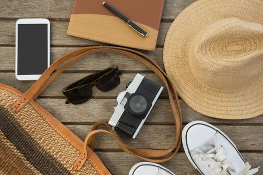 Overhead of travel accessories on wooden plank