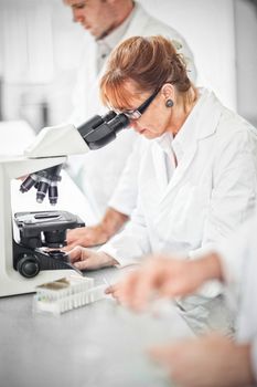 Scientist working on microscope in laboratory 