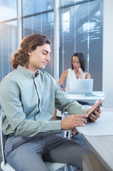 Male executive using digital tablet at desk in office