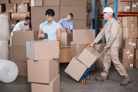 Warehouse workers preparing a shipment in a large warehouse