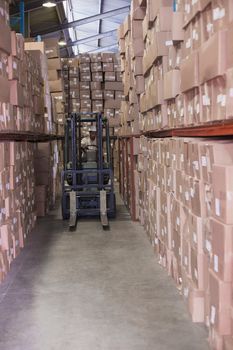 Forklift driver operating the machine in a large warehouse