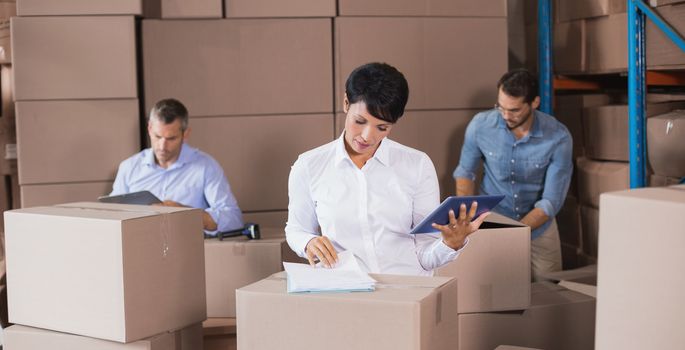 Warehouse workers preparing a shipment in a large warehouse