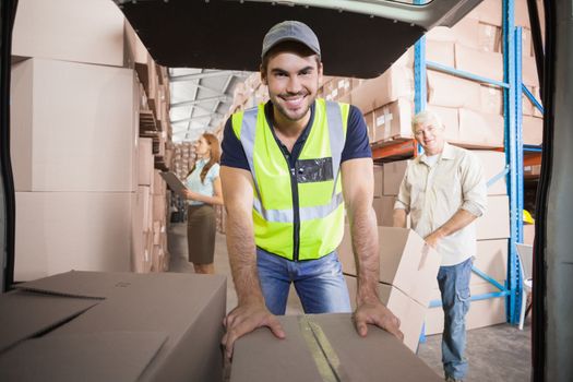 Delivery driver loading his van with boxes outside the warehouse