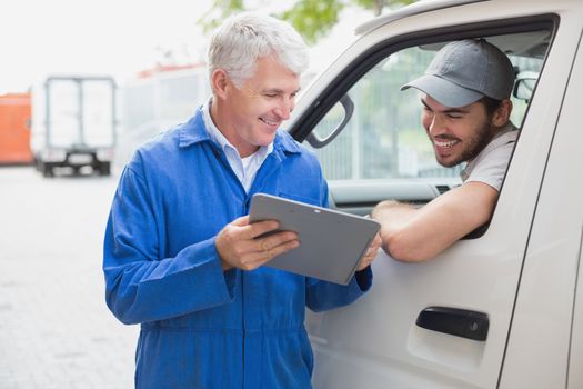 Delivery driver smiling at camera with customer outside the warehouse