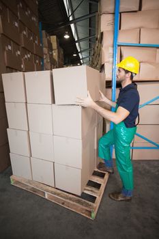 Warehouse worker loading up a pallet in a large warehouse