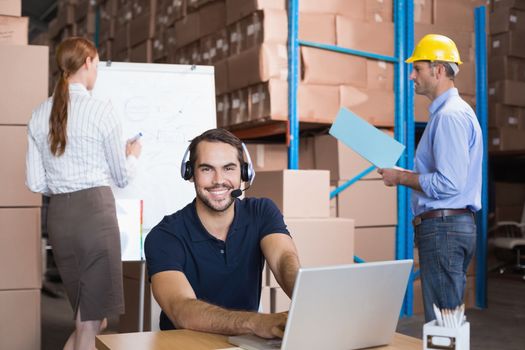 Warehouse team working together on shipment in a large warehouse