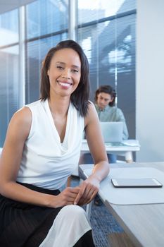 Portrait of female executive sitting at desk in office