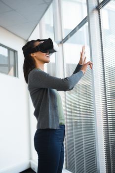 Female executive using virtual reality headset in office