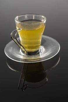 Cup of cinnamon tea on black background