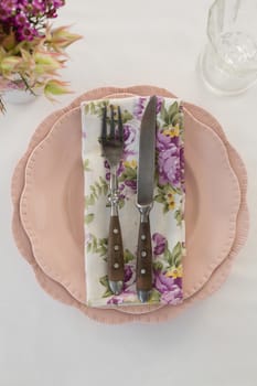 Fork, butter knife and napkin in a plate on white background