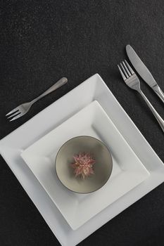 Close-up of elegant table setting with floral arrangement 