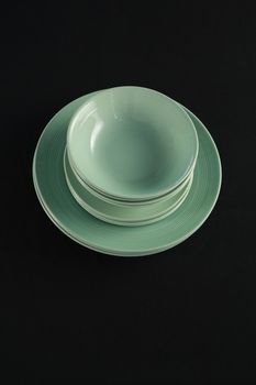 Overhead view of dining plates set on black theme table