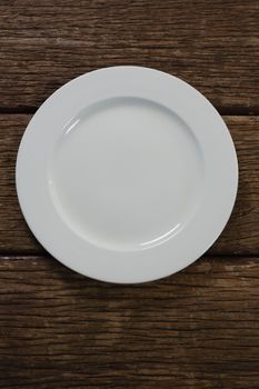 White empty plate on wooden table