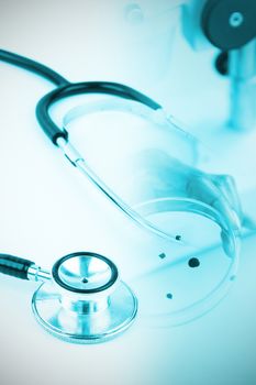 Metal black stethoscope against doctor holding microscope slide
