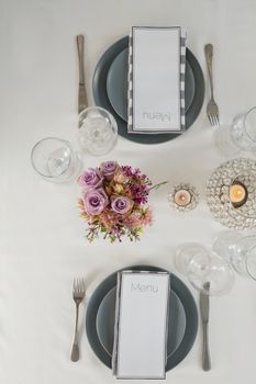 Overhead view of menu card, plate and cutlery set elegantly on a table