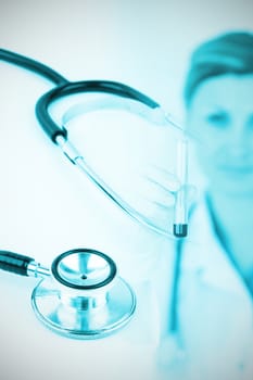 Metal black stethoscope against female scientist looking at the camera while holding a test tube