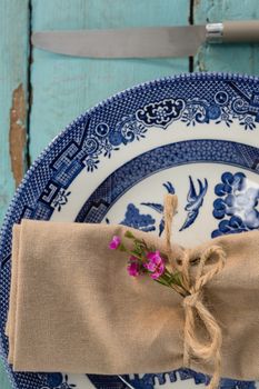 Overhead of tied napkin with flora on plate