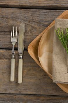 Overhead of flora and napkin arranged on plate with cutlery