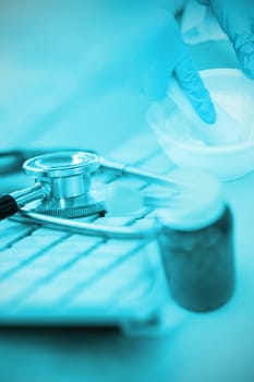 Close-up of keyboard with stethoscope against doctor preparing medicine in laboratory