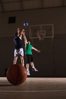 Two players playing basketball in the court