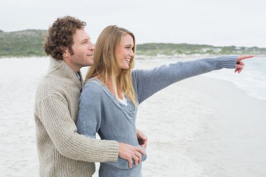 Side view of a relaxed romantic young couple standing together at the beach