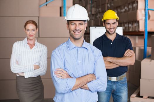 Warehouse team smiling at camera in a large warehouse