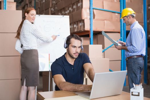 Warehouse team working together on shipment in a large warehouse