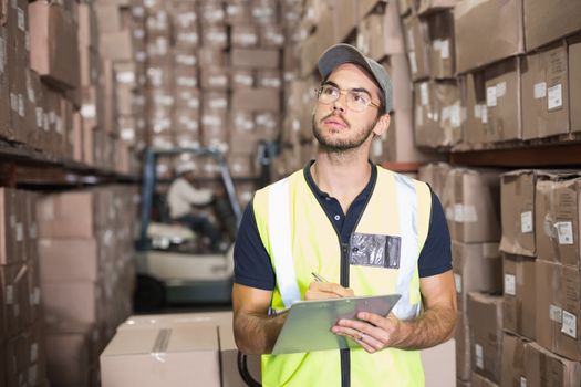Warehouse worker checking his list in a large warehouse