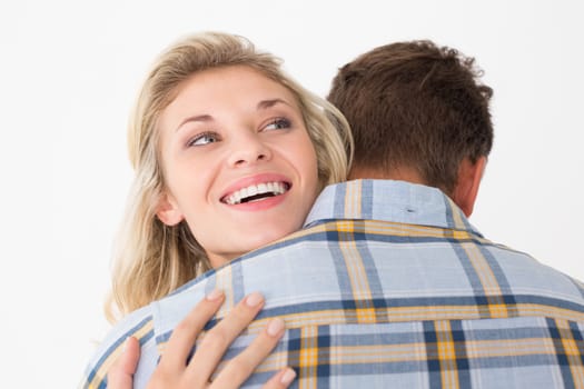 Close up of happy young couple embracing over white background